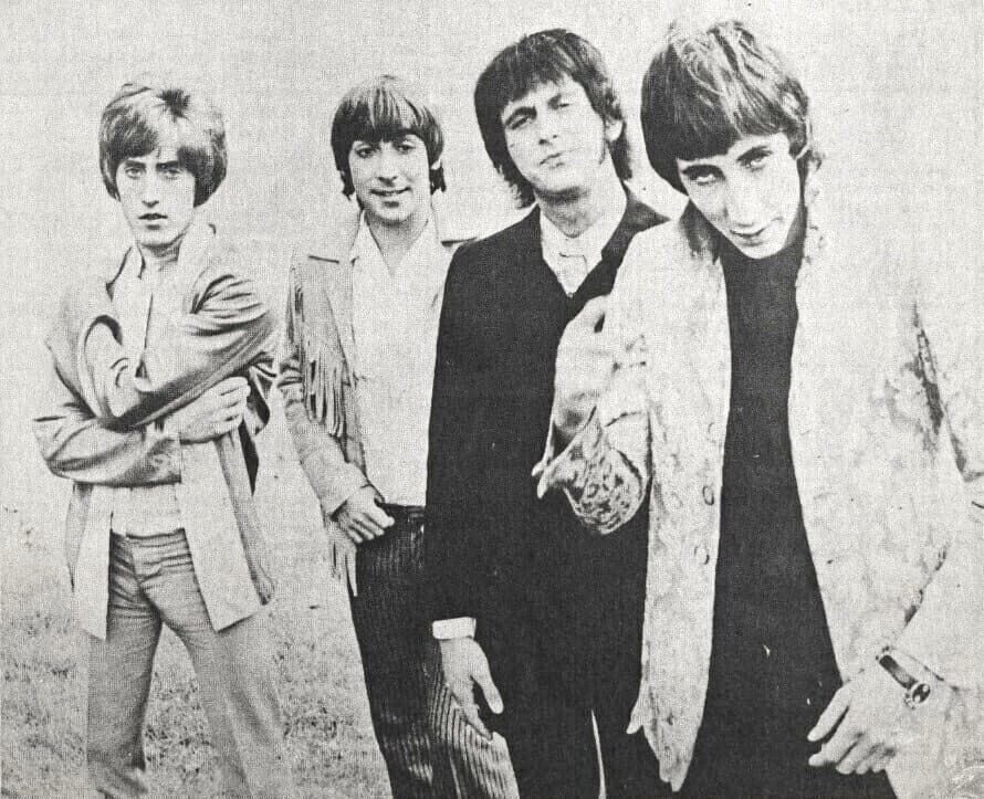 The four members of the Who standing in a field, Townshend at the front in a patterned jacket