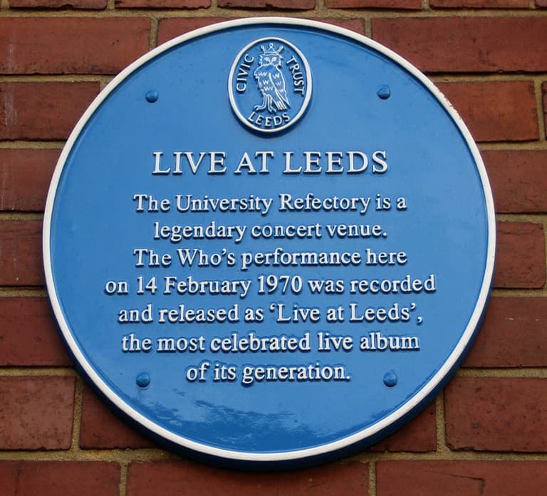 A round blue Leeds Civic Trust plaque on red brick