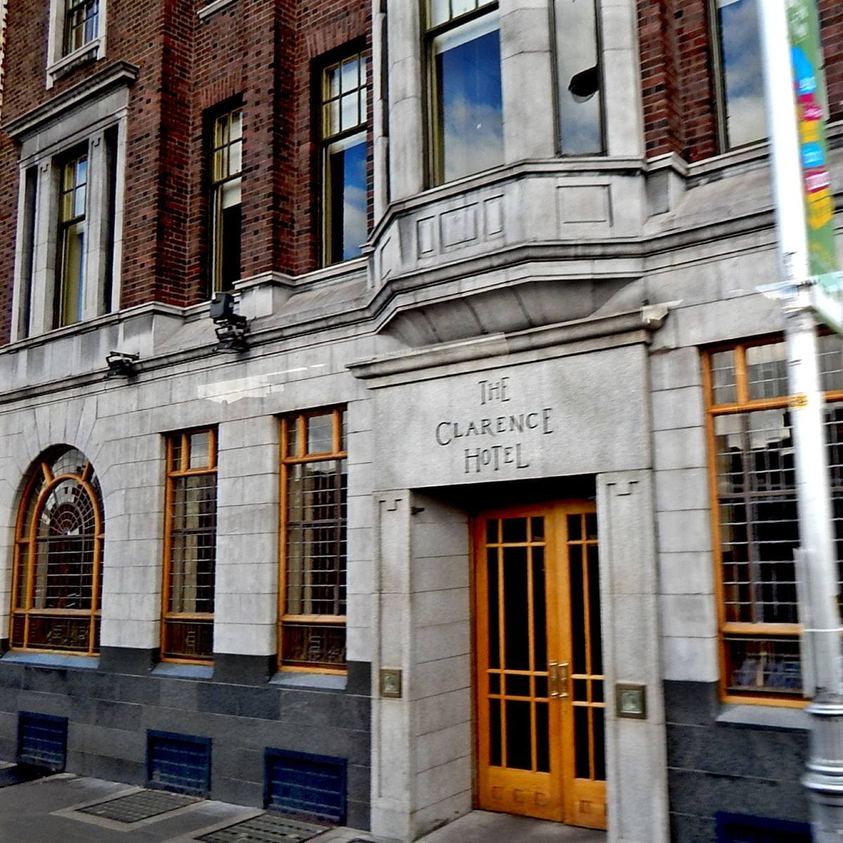 A stone hotel entrance with tall wooden doors and the hotel’s name carved above