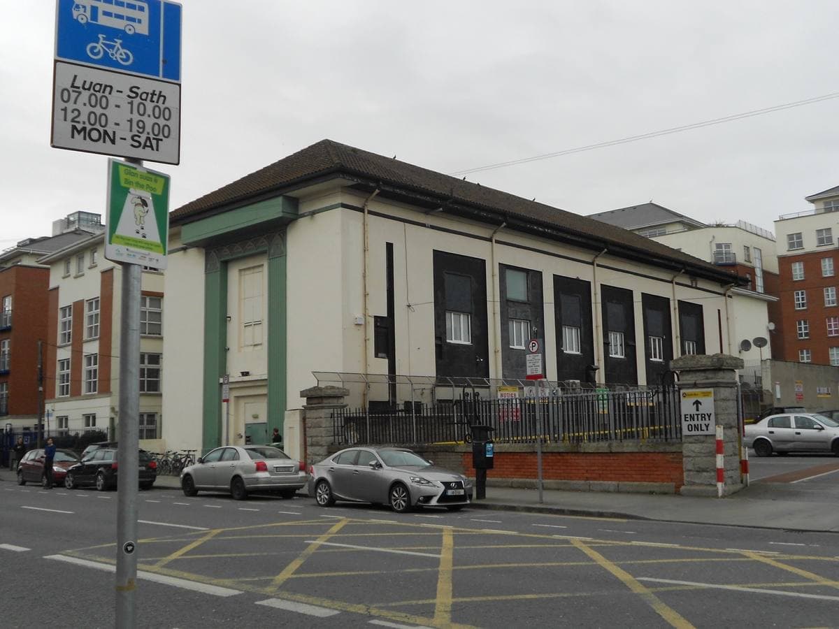 A cream Art Deco building with green pilasters on a Dublin street corner