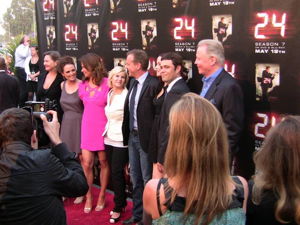 Eight cast members standing in a row on a stage