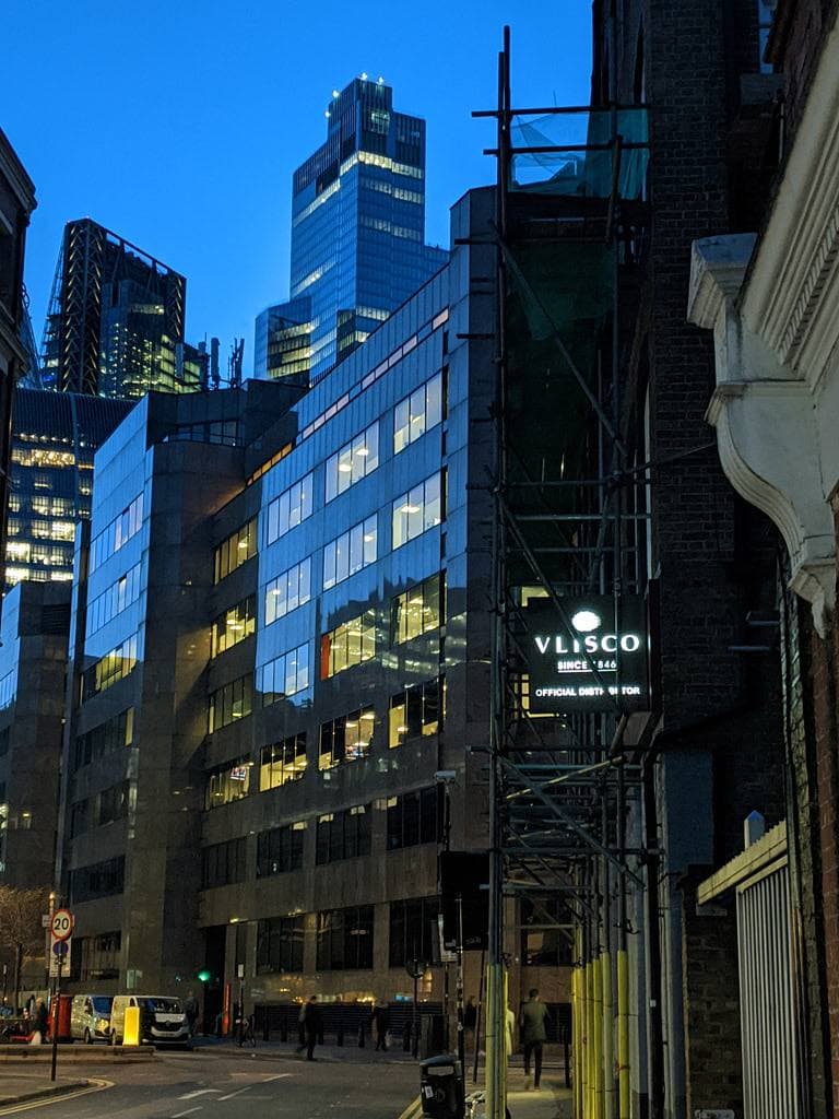 A narrow City street of brick and glass buildings