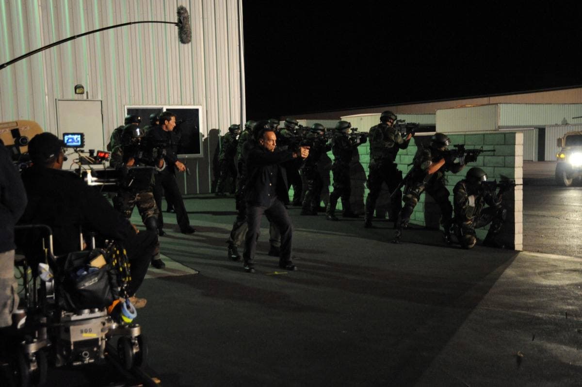 A group of men in uniform crossing an airfield in a staged scene