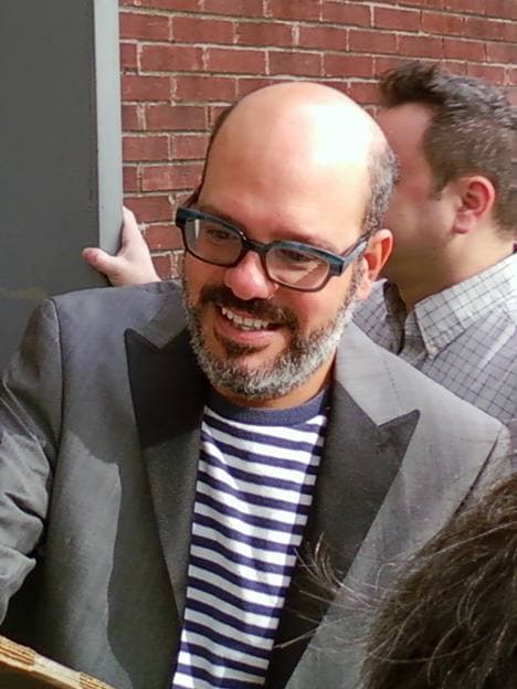 David Cross on stage, bearded, in glasses