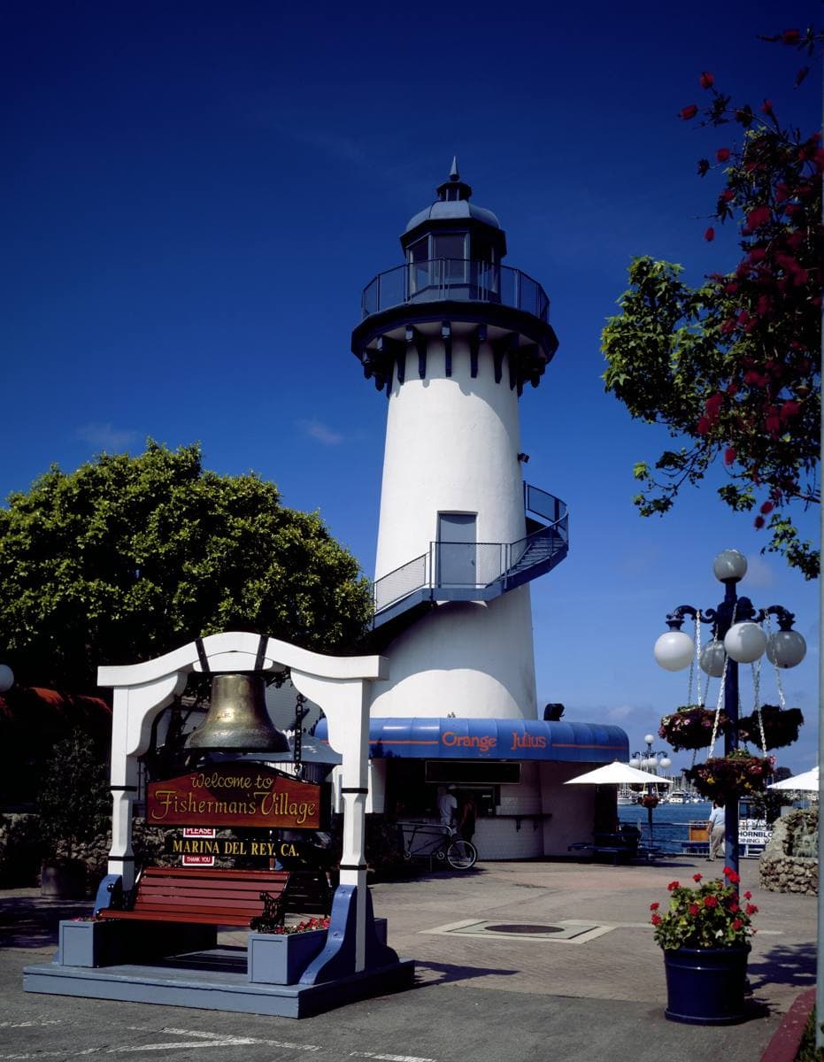 A small white and red lighthouse beside the harbour at Marina del Rey