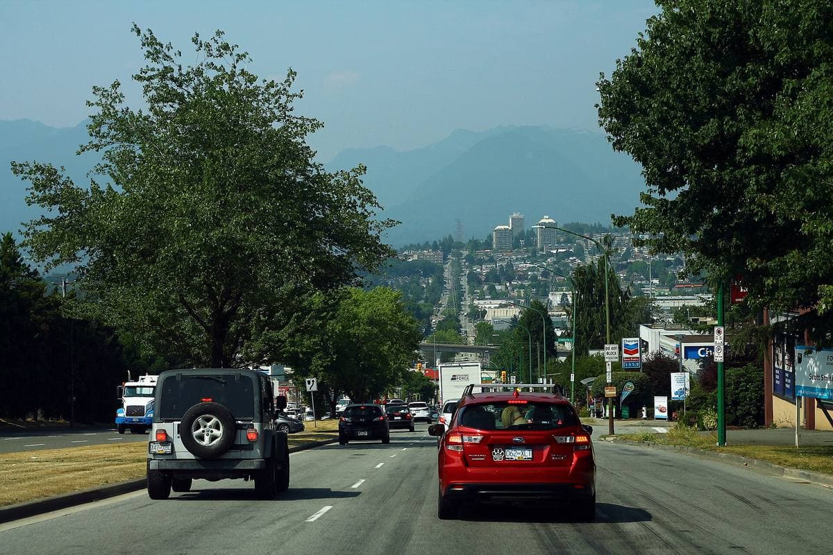 A multi-lane road with trees and street lights