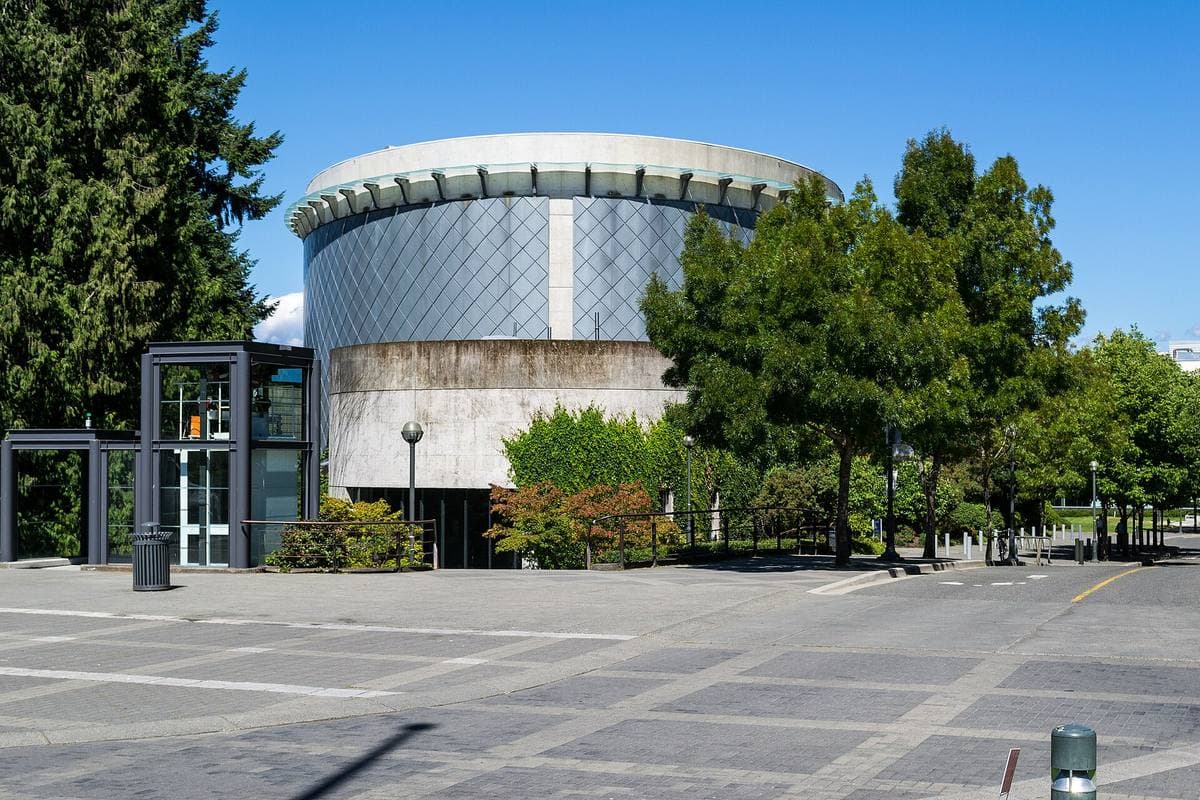 A cylindrical modern concert hall among trees