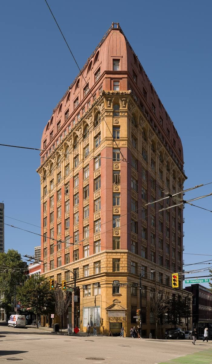 A tall early-1900s office building with a red roof