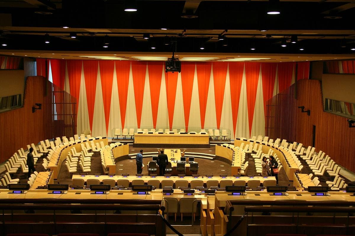 A large council chamber with curved desks and an open ceiling