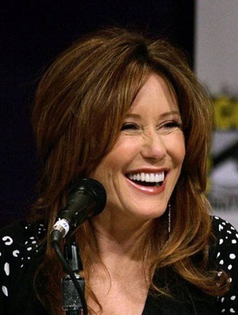 A woman with shoulder-length reddish hair speaking on a panel