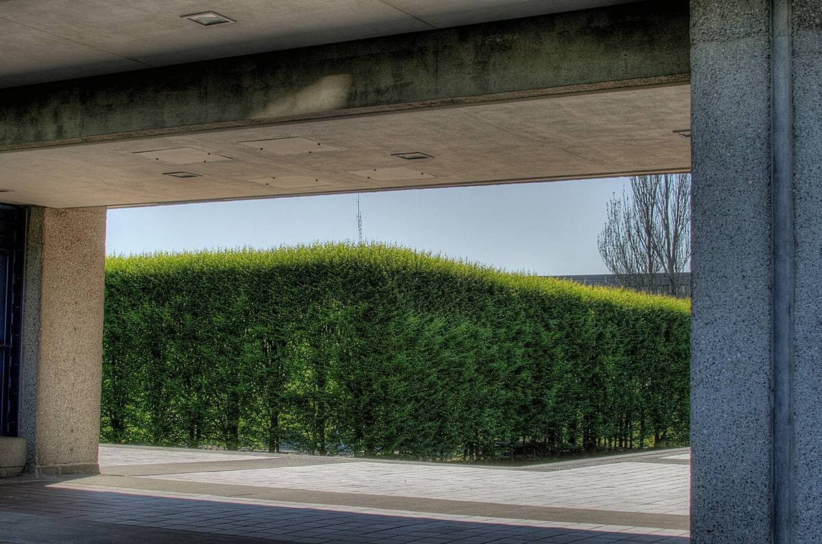 A long concrete colonnade round a lawn courtyard