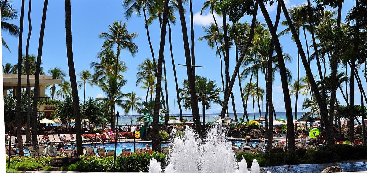 A panorama of resort towers along a beach and lagoon
