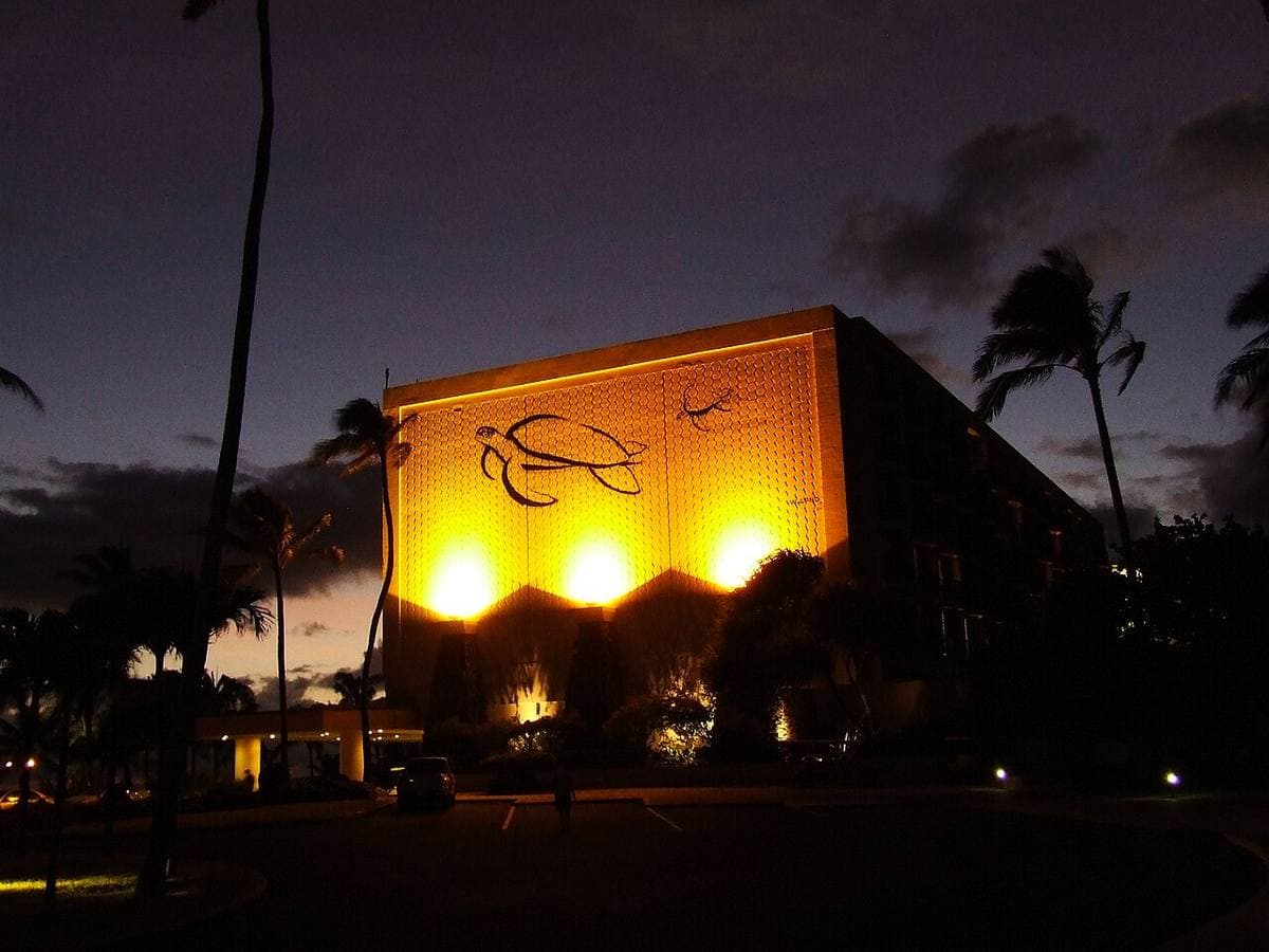A low resort building on a rocky point at dusk