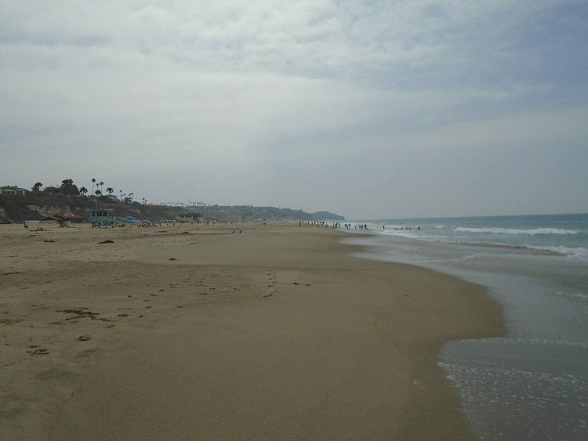 A long wide beach in Malibu with low surf