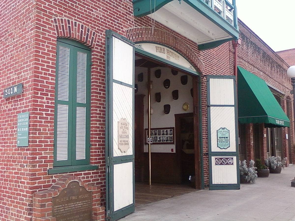 A small two-storey brick firehouse on a corner at night
