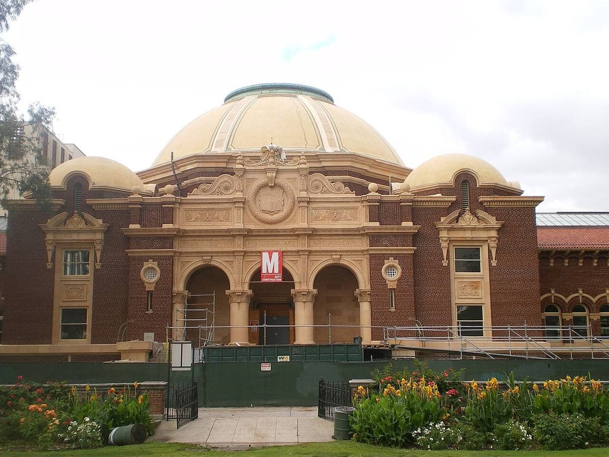 A Beaux-Arts museum building with domes behind a garden