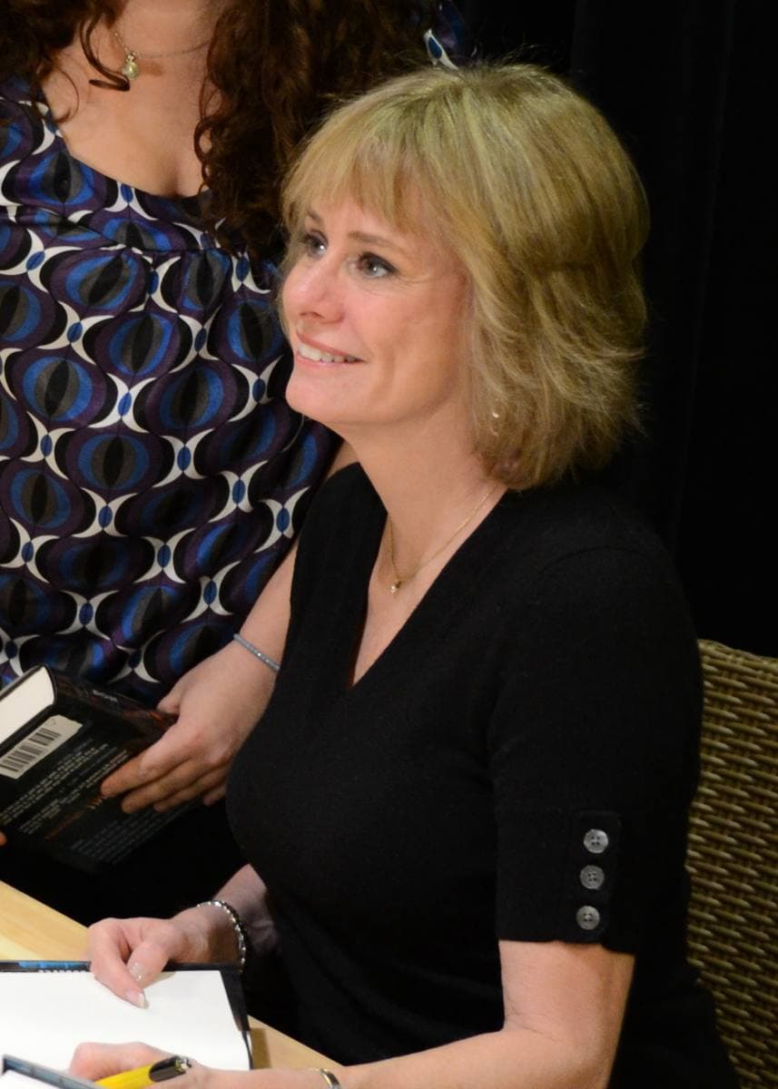 A woman with short fair hair smiling at a book signing