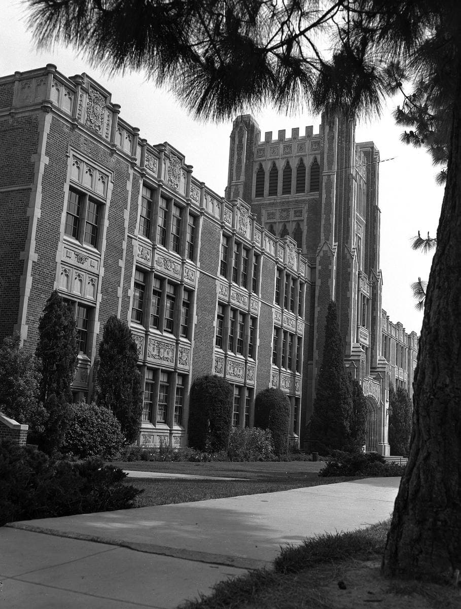 A black-and-white photograph of a Gothic-style school building with a tower