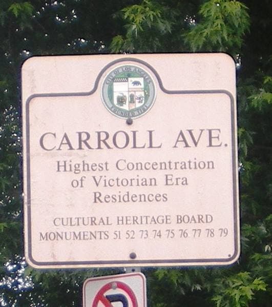 A small heritage sign on a post naming Carroll Avenue as a Los Angeles Historic-Cultural Monument