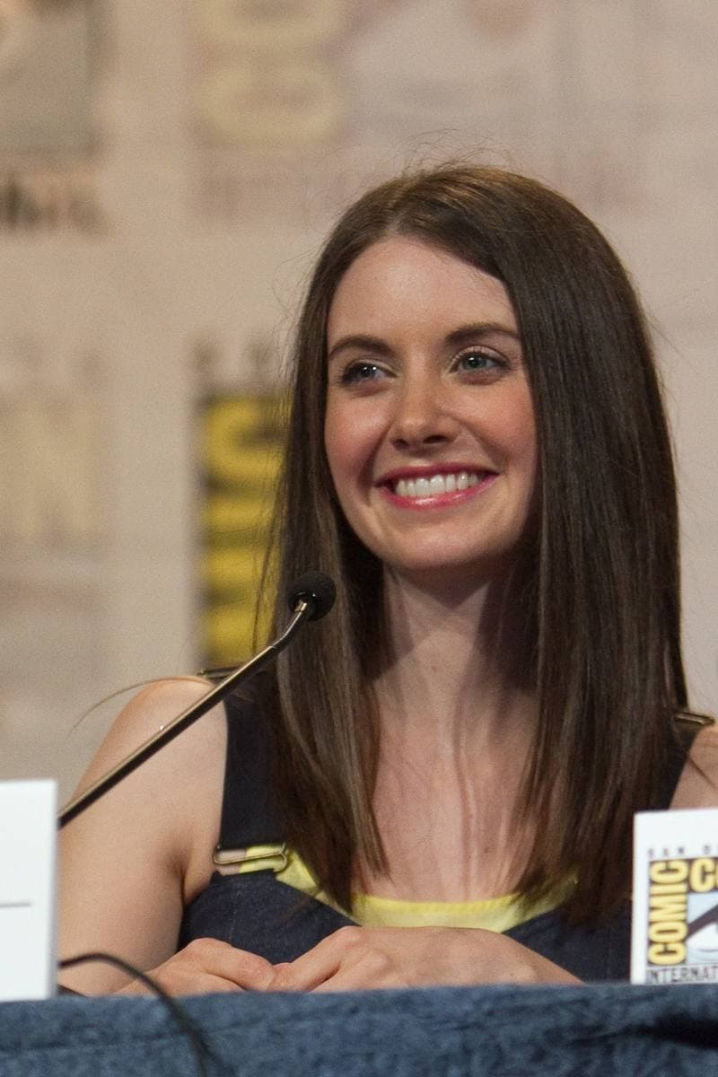 A smiling young woman with dark hair at a convention