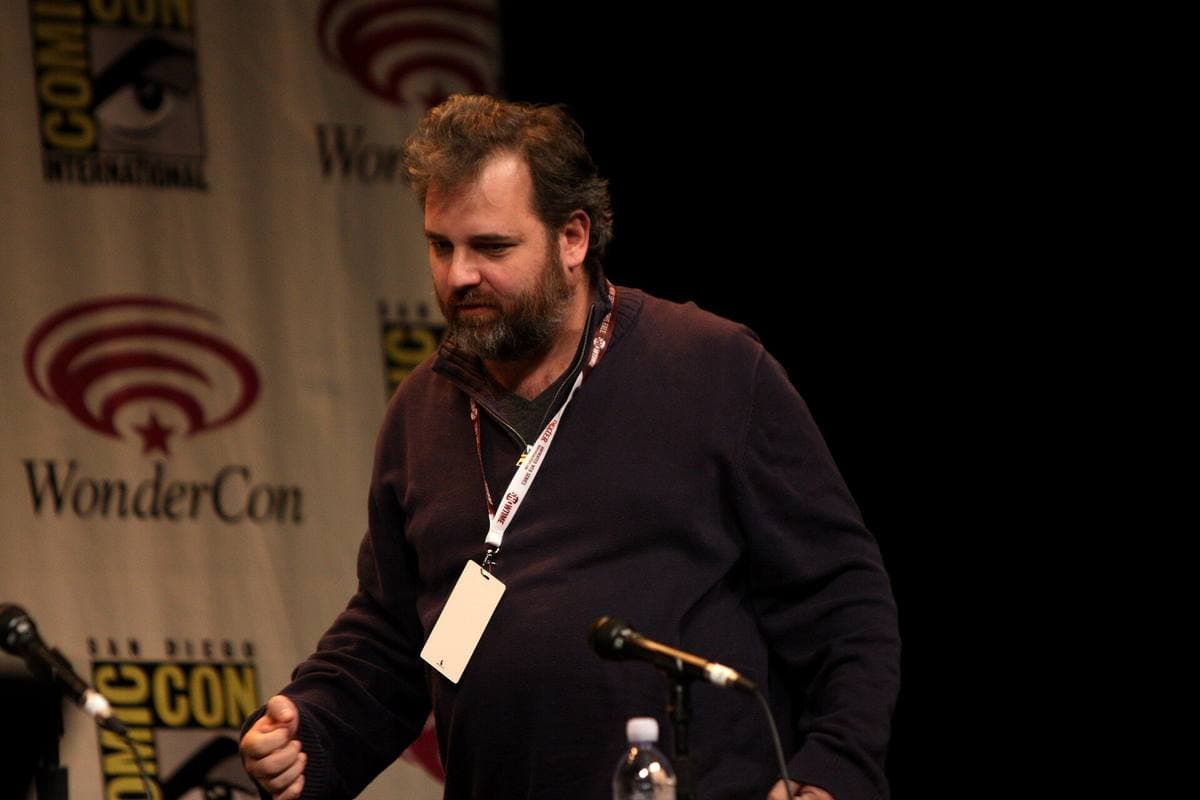 A bearded man speaking at a panel table