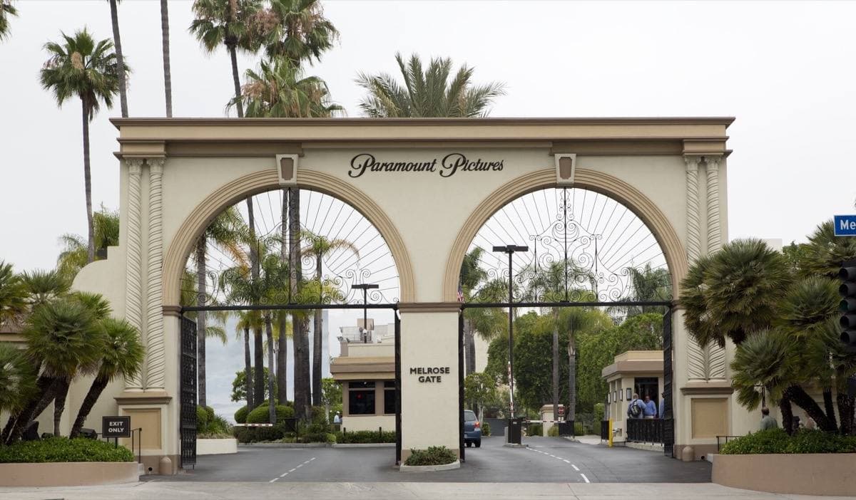 The arched Paramount Pictures gate on Melrose Avenue under a blue sky