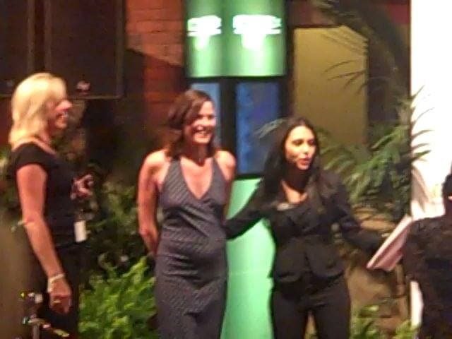 A woman with dark hair speaking at an event in a casino