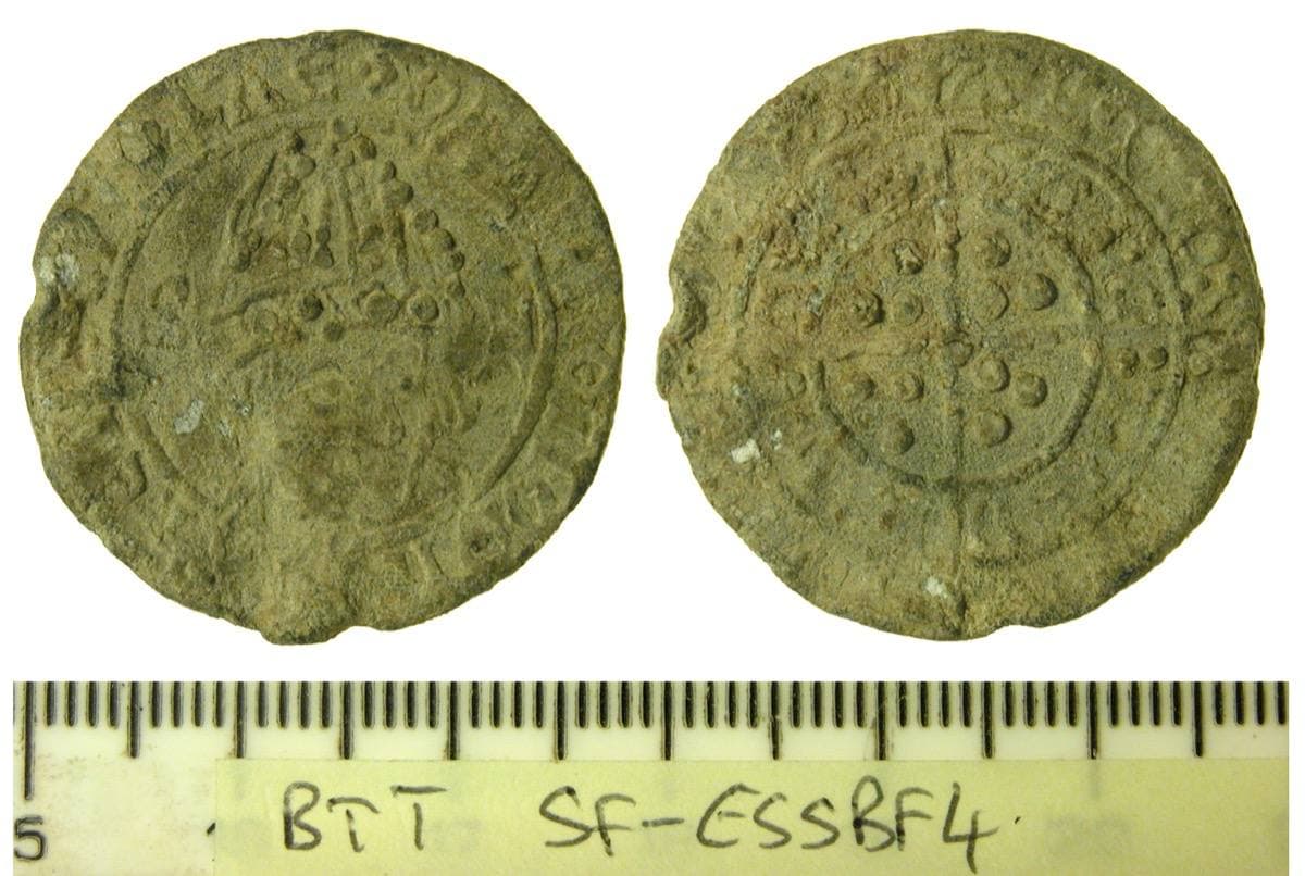 Both faces of a grey lead disc stamped with a mitred bust and a long cross