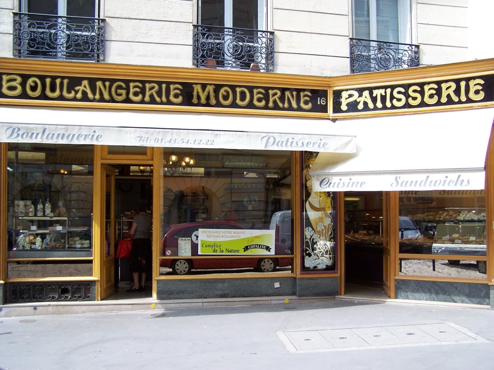 A bakery shopfront with gold lettering on a black fascia reading Boulangerie Moderne and Pâtisserie