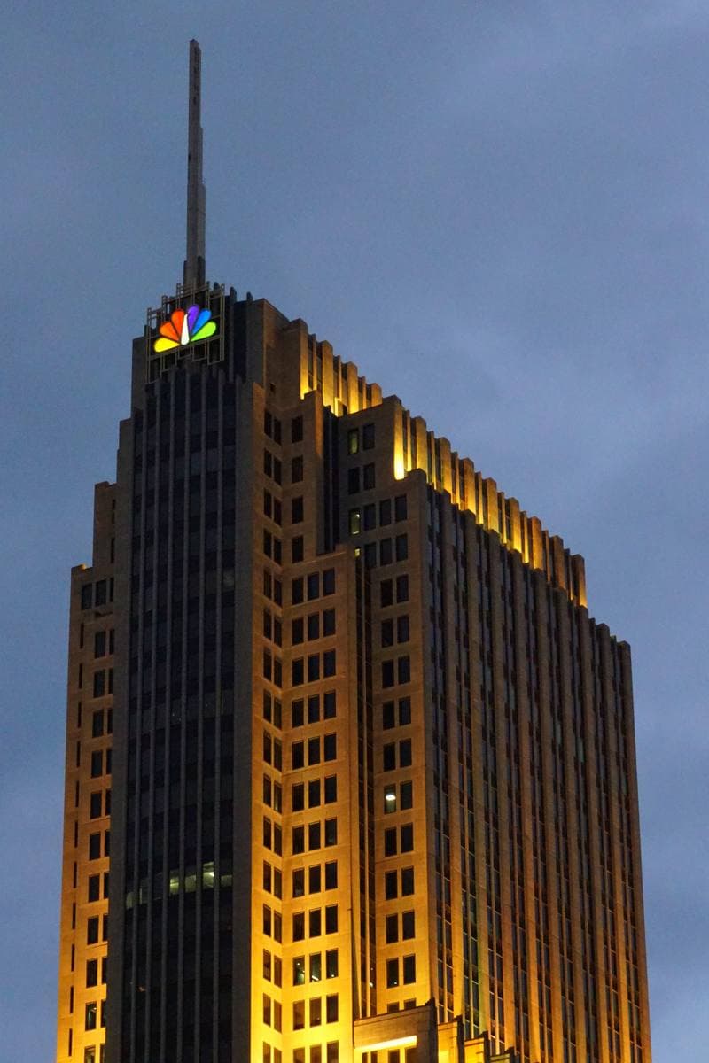 A stepped limestone tower lit gold at dusk against a blue sky