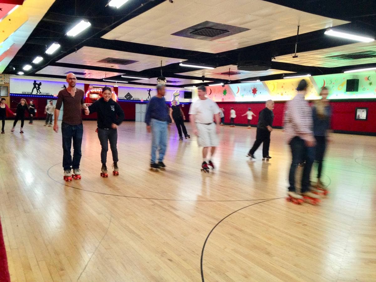 A wooden roller-skating floor under coloured lights