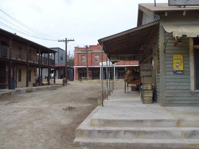 Wooden false-front buildings of a western film town on a dirt street