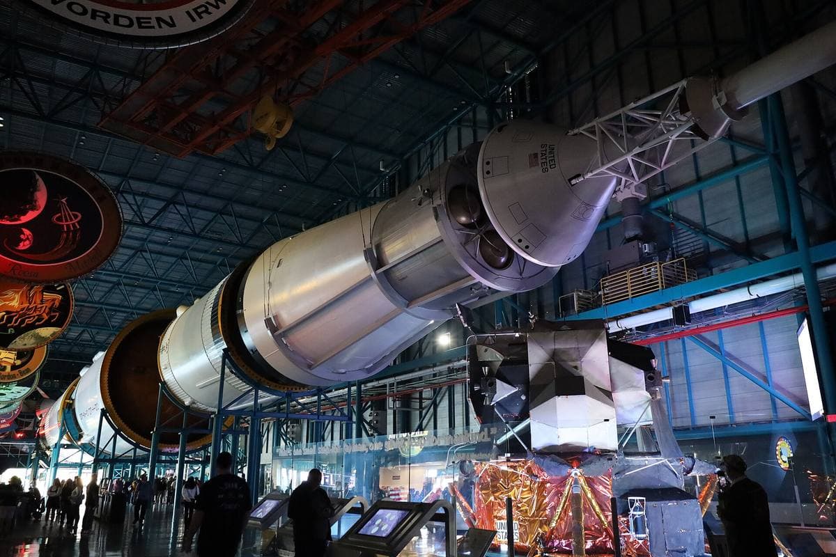 A huge white rocket stage lying horizontally in a long museum hall