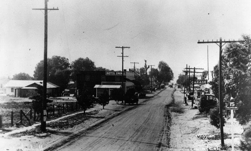 An old photograph of a small-town street with a hotel