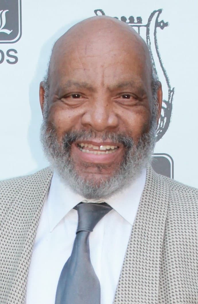 James Avery in a dark suit on a red carpet