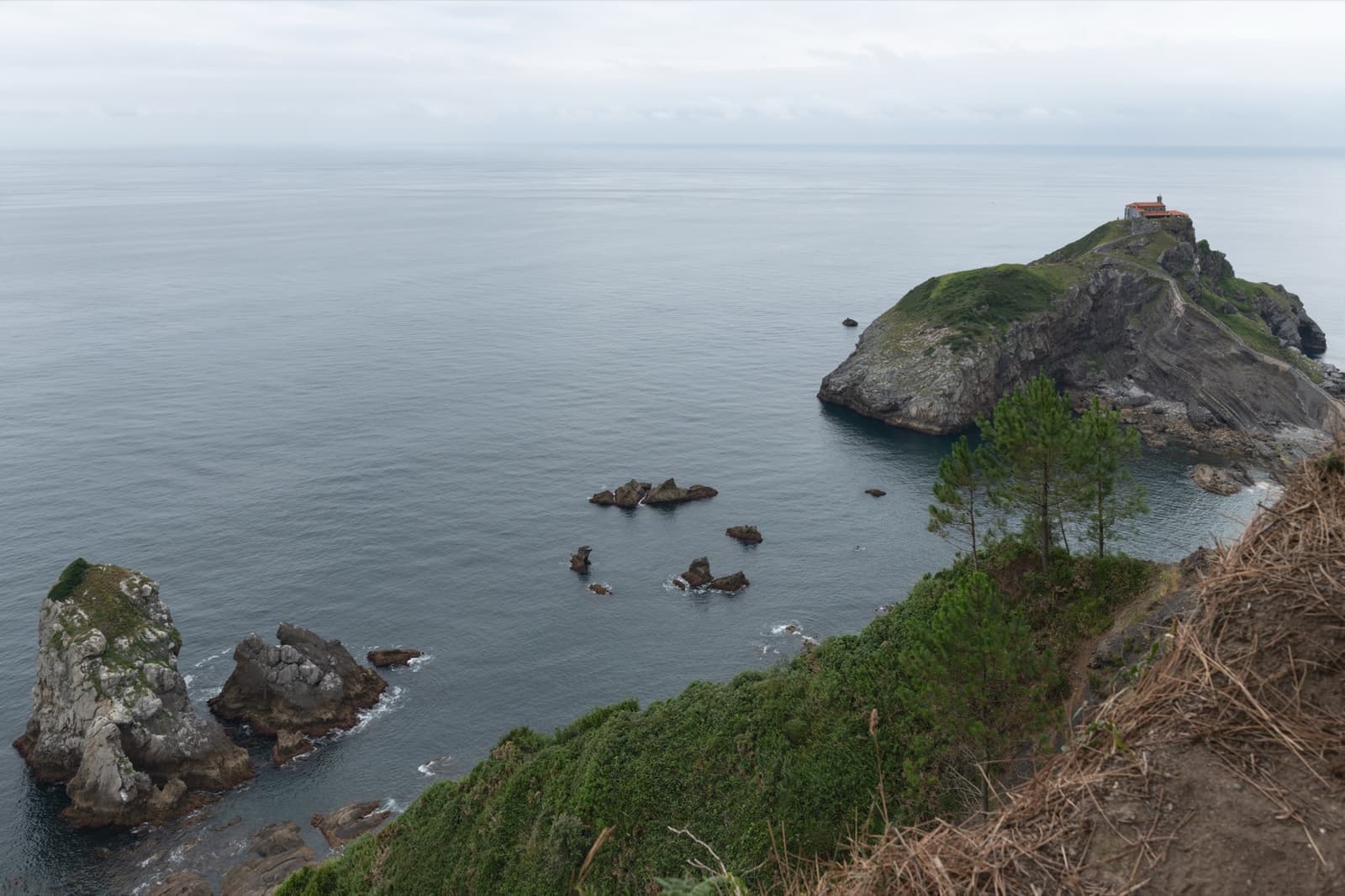 A rocky islet joined to the coast by a stone causeway and steps