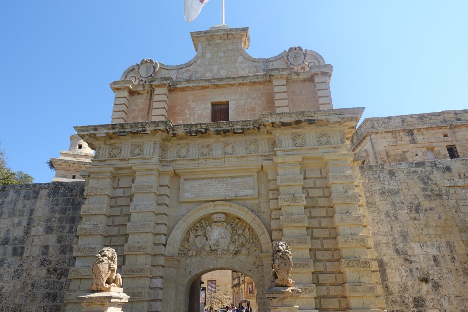 A baroque stone city gate reached by a bridge