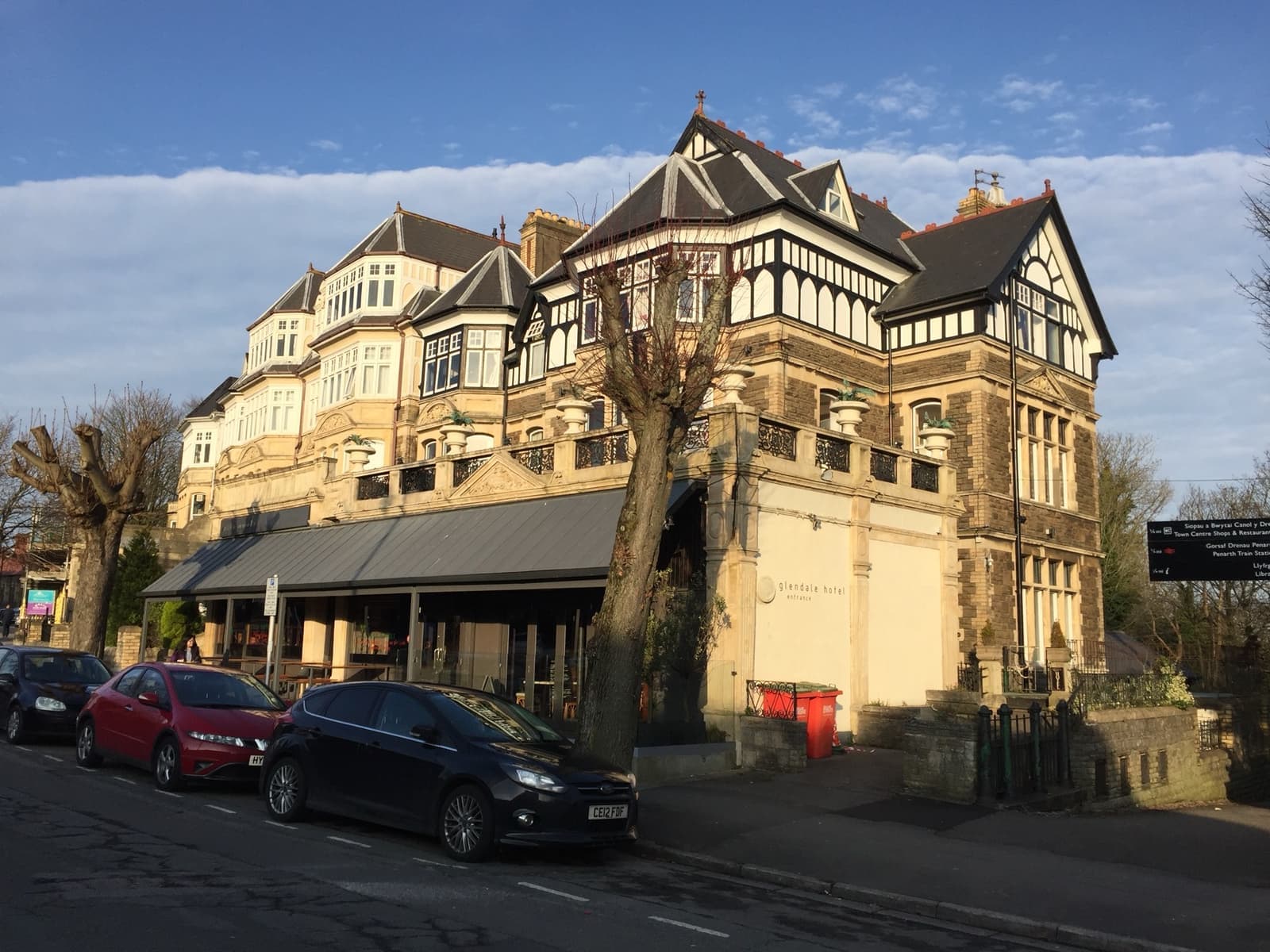 A tall Victorian terrace with mock-Tudor gables and a canopy over the pavement