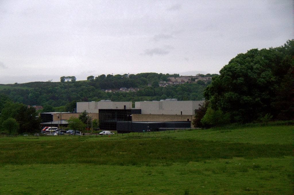 Grassed pyramid earthworks beside an industrial estate