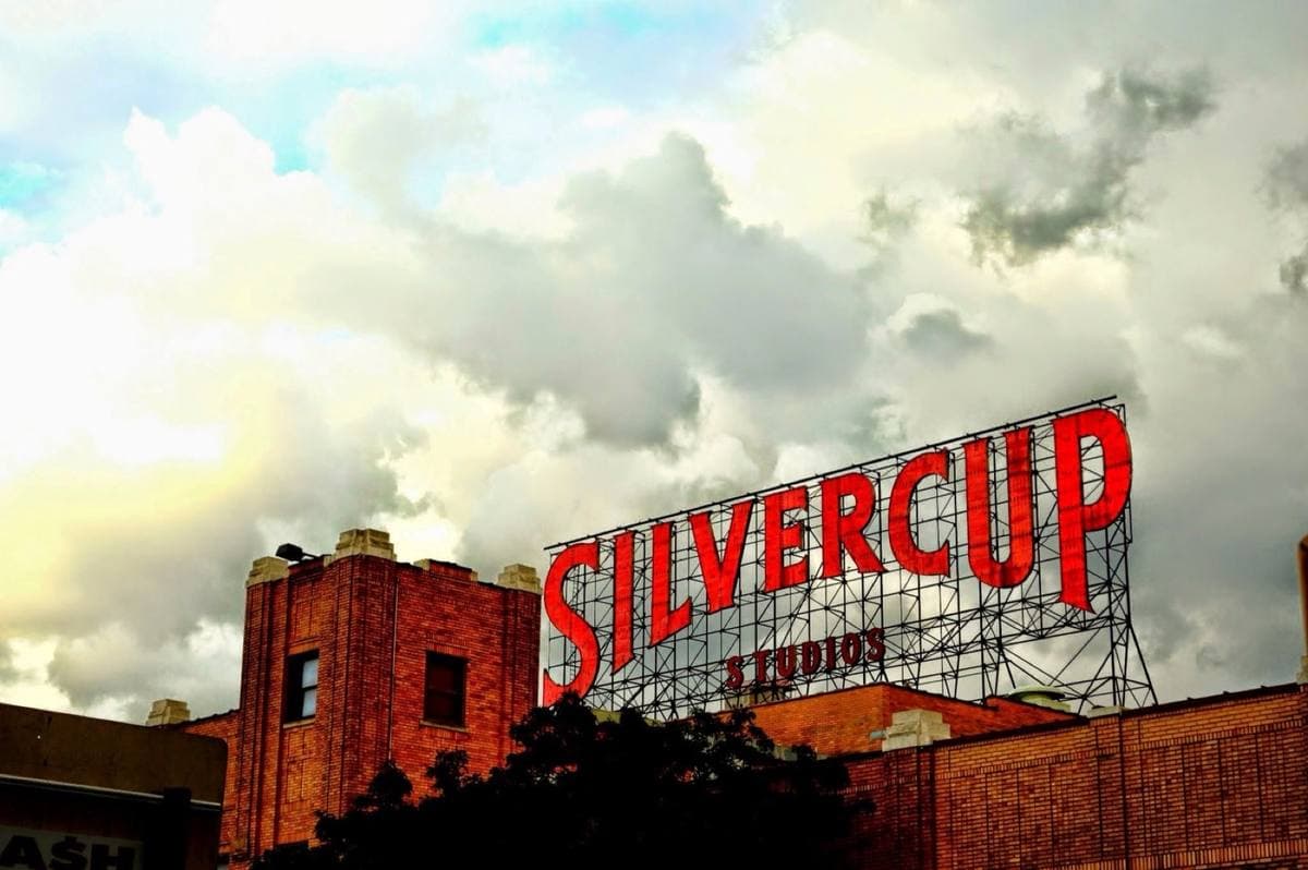 Big red letters spelling Silvercup on a rooftop frame against a cloudy sky