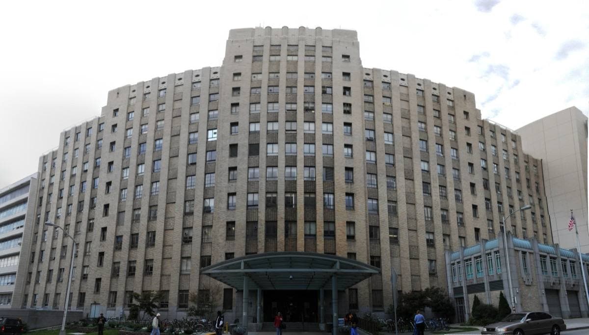 A tall pale brick Art Deco hospital tower