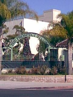 A studio gate with a guard booth under palm trees