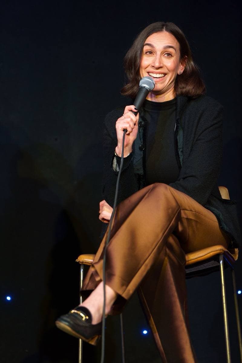 A woman with long hair speaking on a panel