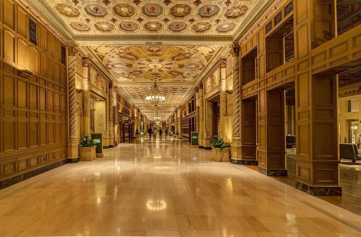 An ornate hotel interior with a painted, gilded ceiling