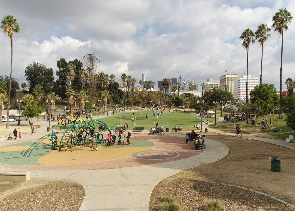 A city park with playing fields and office towers beyond