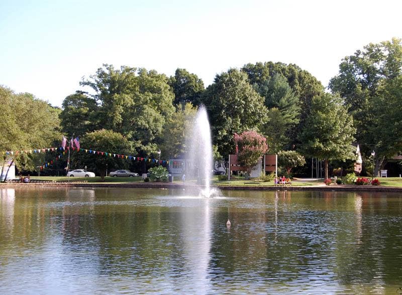 A lake with trees round it in a city park