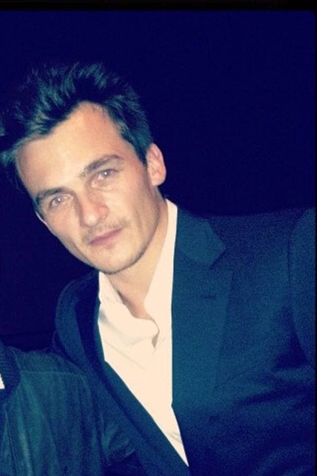 Rupert Friend, dark hair, in a dark suit