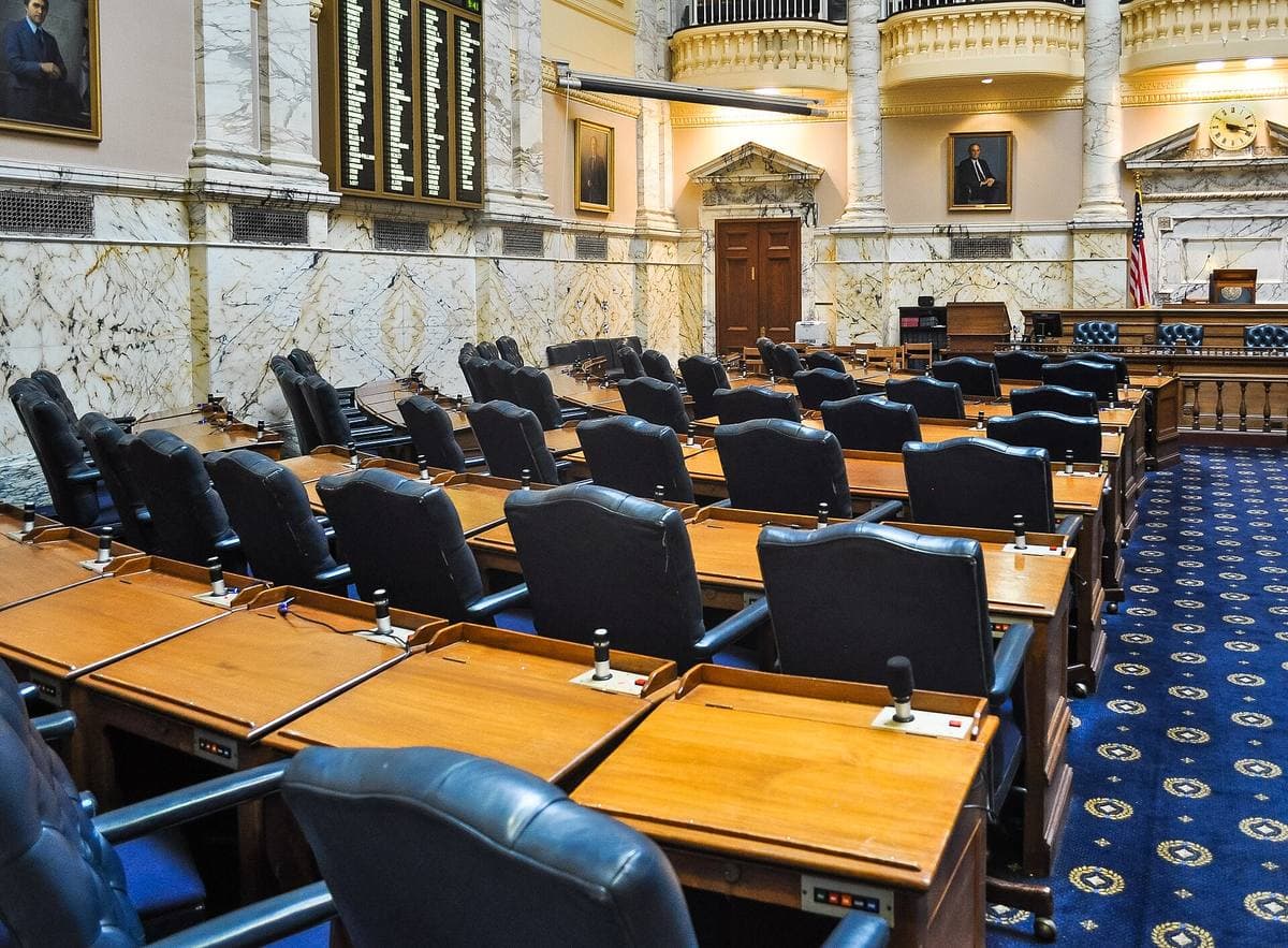 A legislative chamber with rows of desks under a skylight