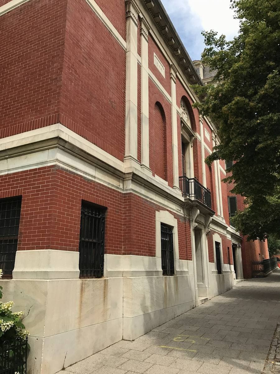 A brick and stone institutional building on a city street