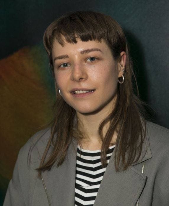 A young person with short fair hair looking to one side